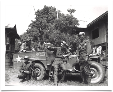 Maj. Claro Camacho, Chief signal officer of ECLGA with Radio Operators Cordero and Acosta and driver, Delfin Domingo with Jeep captured from the Japanese